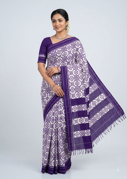 Traditional Indian woman wearing royal purple and white double ikkat cotton saree on clean studio backdrop