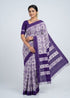 Traditional Indian woman wearing royal purple and white double ikkat cotton saree on clean studio backdrop