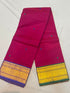 Rani pink Kanchi cotton saree showcasing fine woven buttas and contrasting purple and green gold zari borders with running blouse piece.