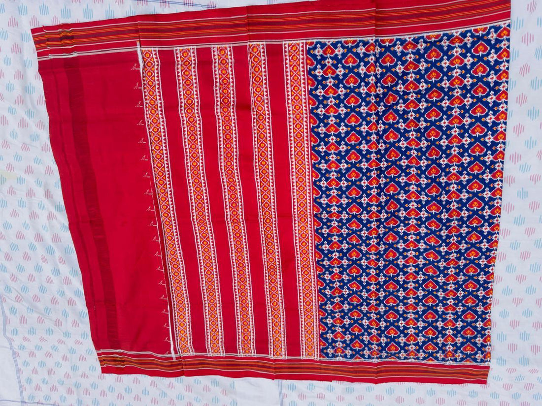 Flat lay of an authentic double ikat patola silk saree with a royal blue geometric patterned body, red striped pallu, and Silk Mark certification