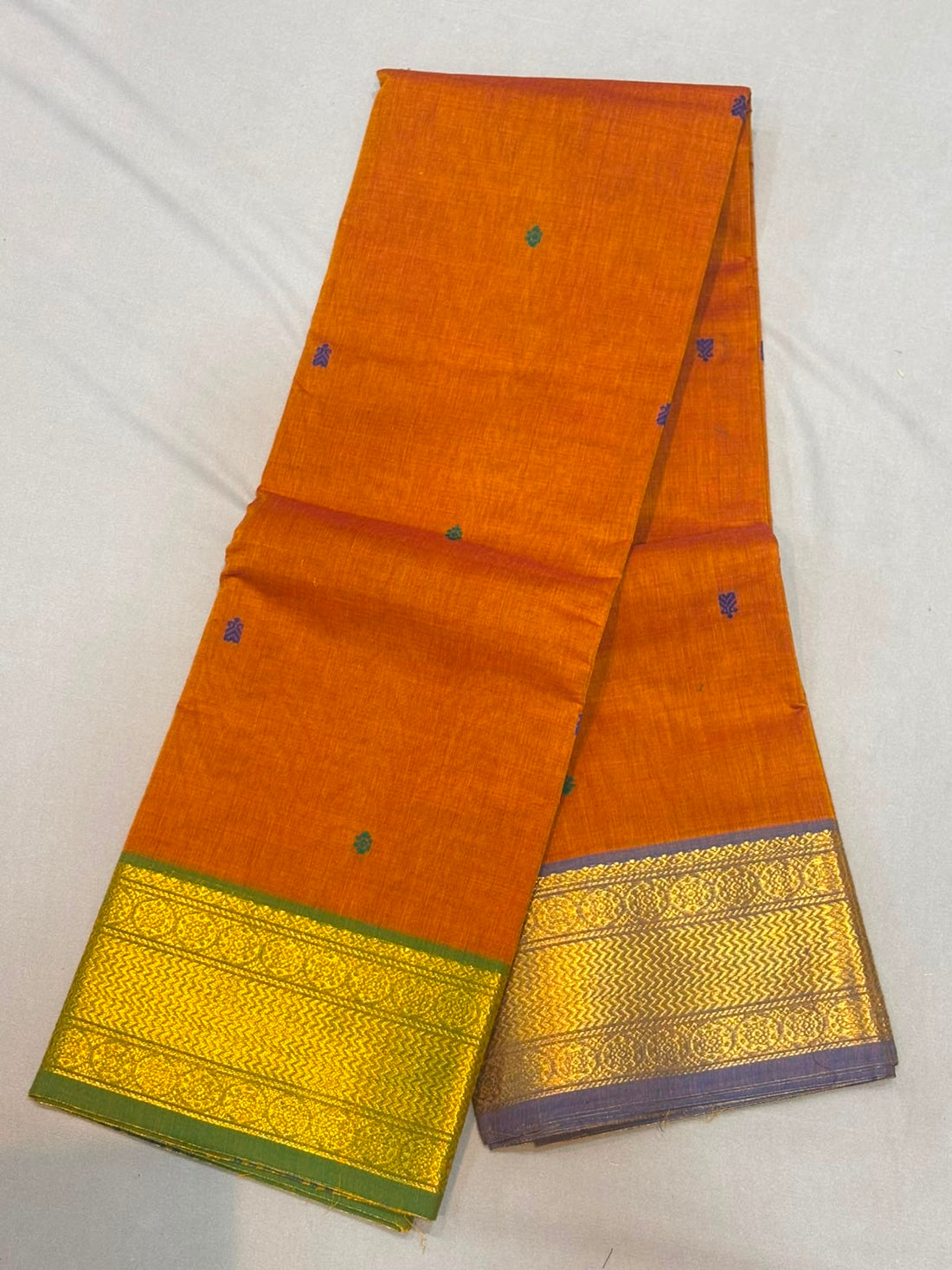 Handloom rust orange pure Kanchi cotton saree with small teal-blue buttas and dual Ganga Jamuna borders in olive green and slate lavender with gold zari