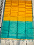 Silk Mark certified mustard yellow Kanchi soft silk saree featuring gold coin buttas and a rich peacock teal brocade pallu with tassels
