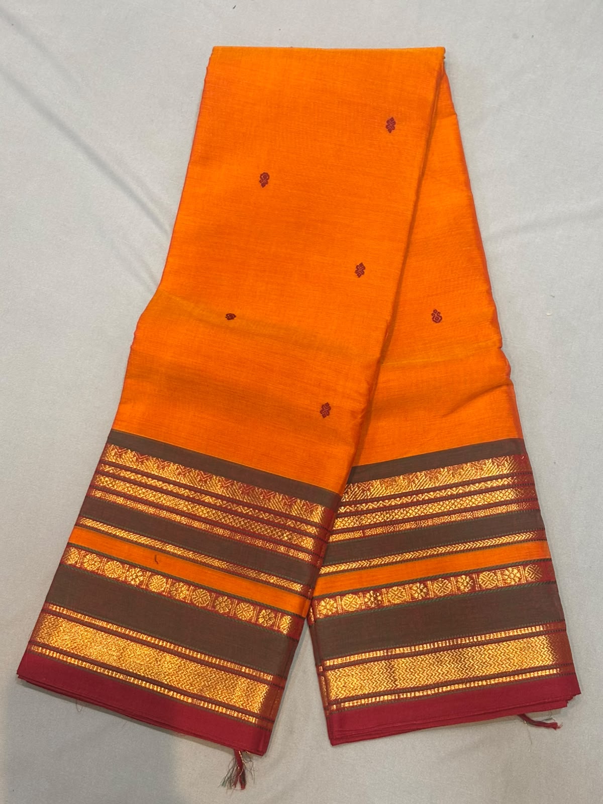 Handloom tangerine orange pure Kanchi cotton saree with maroon floral buttas and charcoal grey gold zari striped border