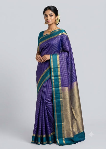 A woman in a traditional pose wearing a violet pure Kanchipuram silk checks saree with a contrasting teal green and gold zari border against a light grey background.